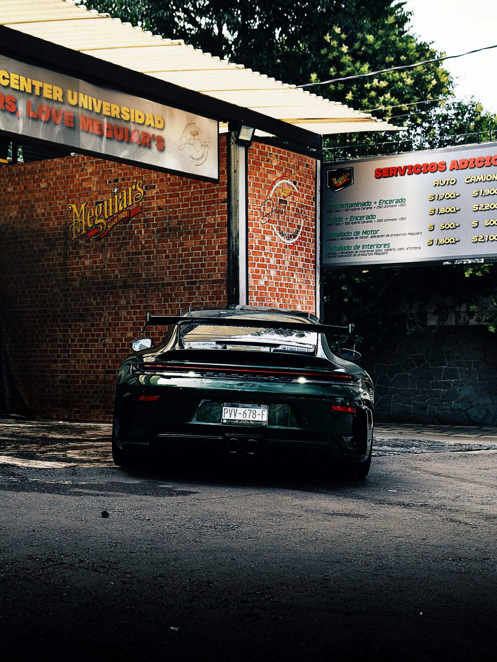 Porsche 911 verde en el patio de la sucursal Universidad de Meguiars Detail Center